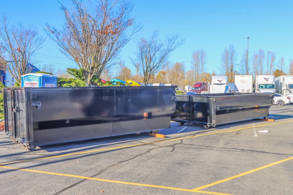 Professional dumpster rental service with roll-off container on residential driveway in El Granada